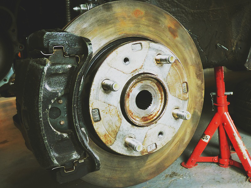 Car brake disc and pad close-up, highlighting wear and tear