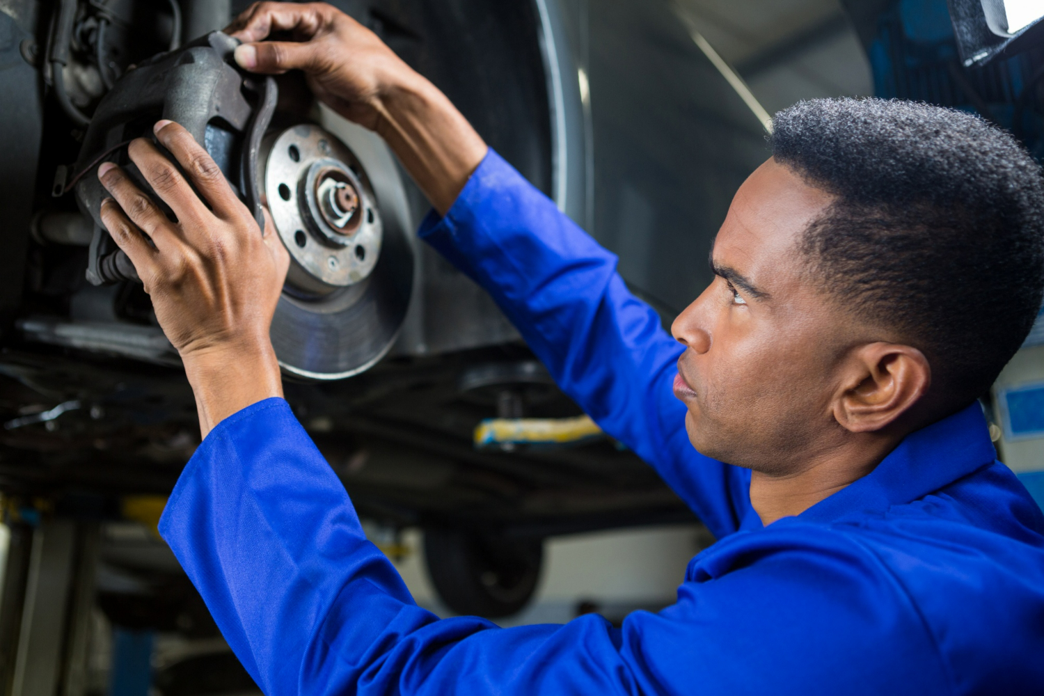 Mechanic working on a brake system for a brake fluid flush