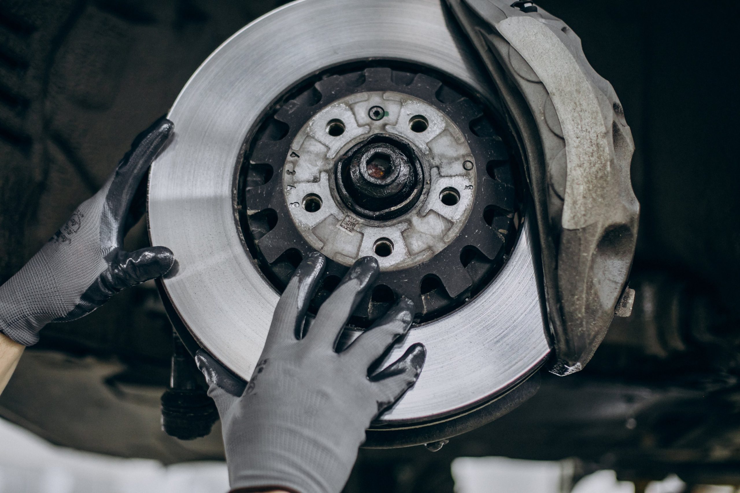 Mechanic replacing brake discs and inspecting a clutch pressure plate
