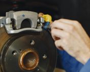 Close up look of a man performing brake service on a car
