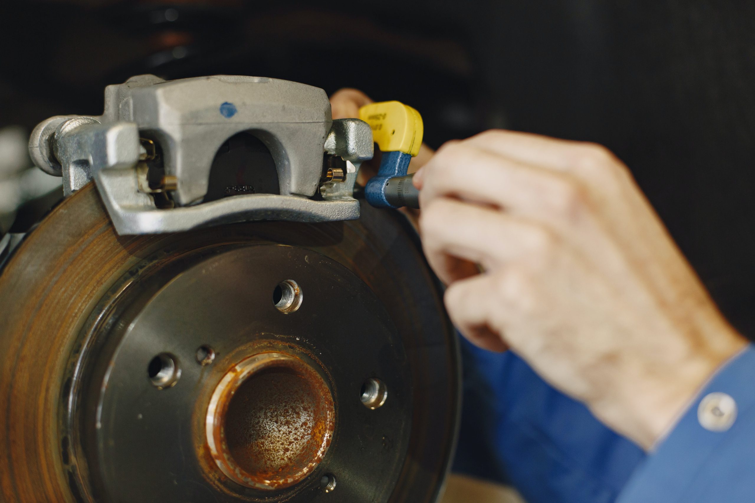 Close up look of a man performing brake service on a car
