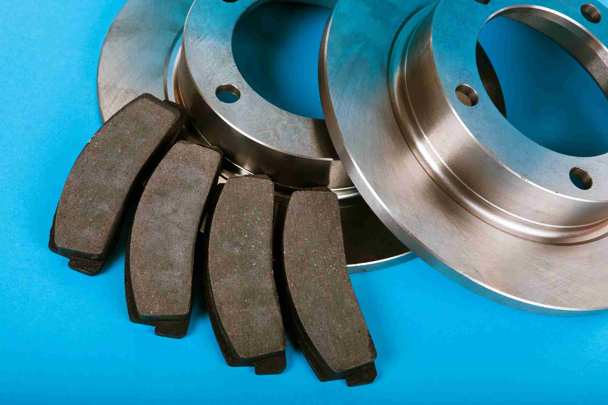 Close-up of the best brake pads for trucks with metallic brake discs on a blue background.