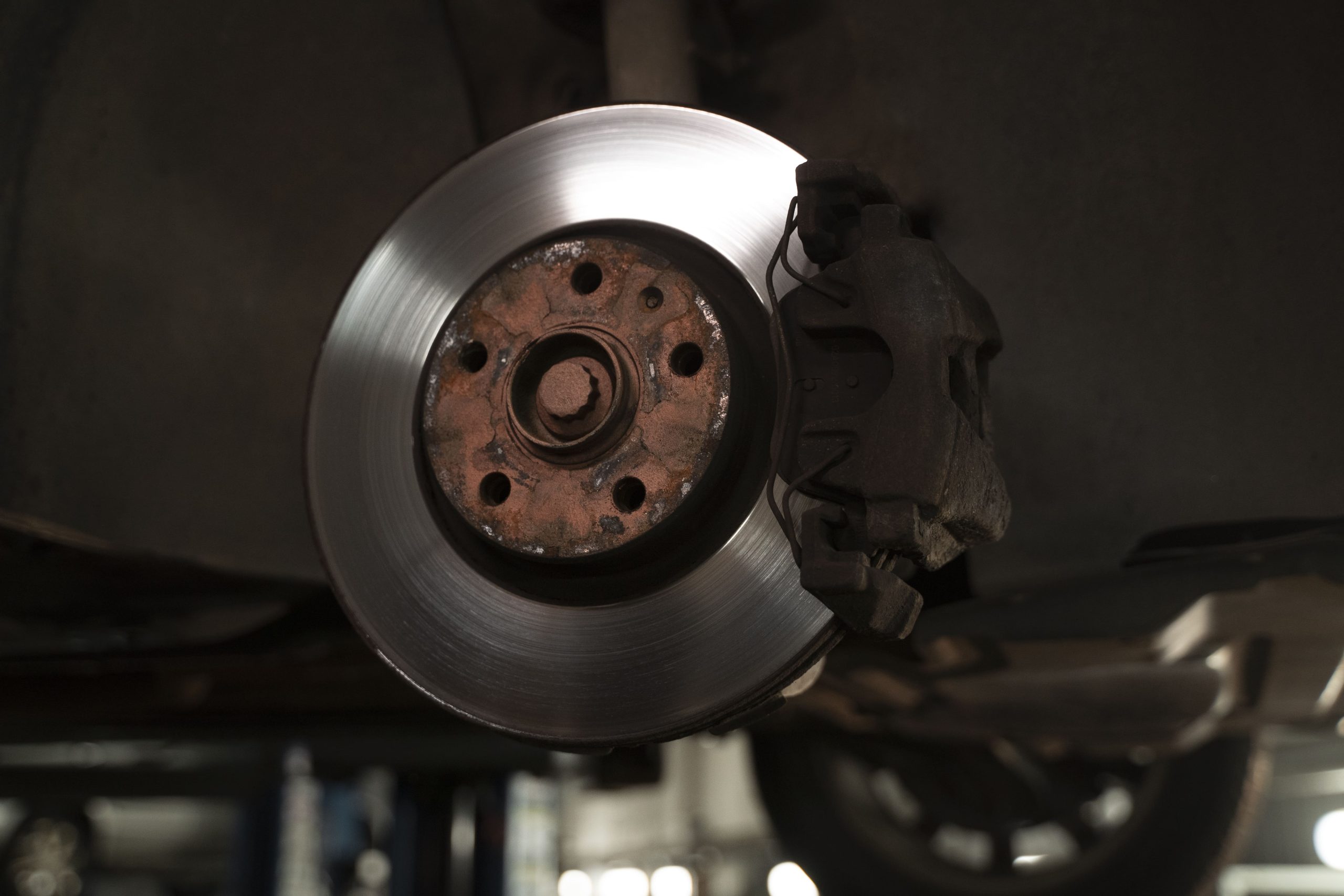 A lone brake installed into an elevated passenger vehicle in a repair shop